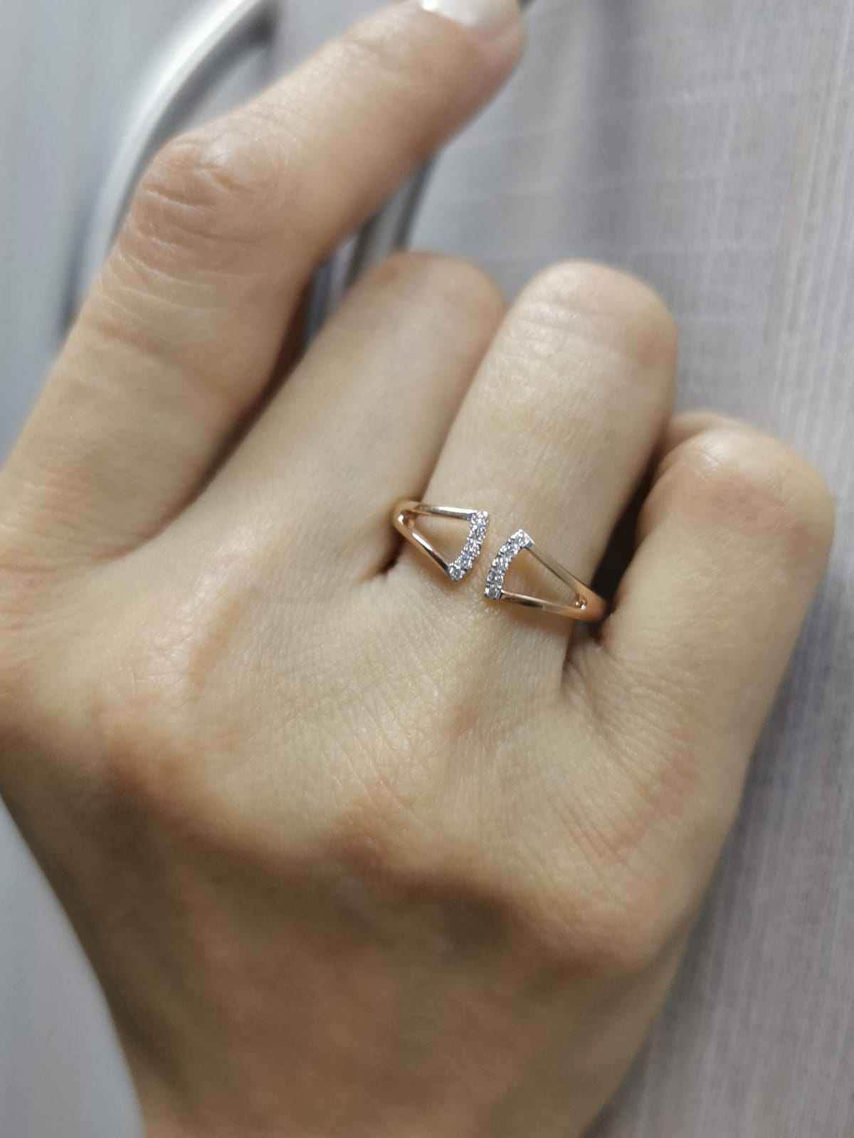 18K gold open-style ring with a geometric split shank and 0.07 carats of diamonds.