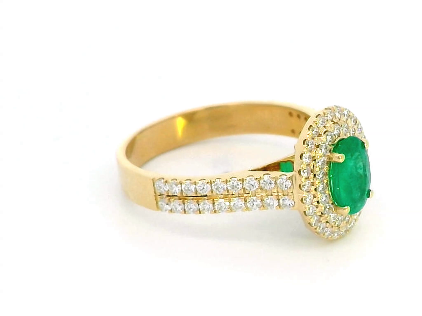 Luxury 18K gold emerald and diamond ring featuring a 0.53-carat oval-cut emerald, encircled by a double halo of 0.54-carat diamonds with a pave-set split shank design – a perfect statement ring for women.