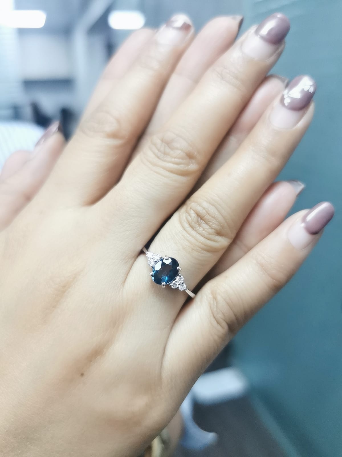 18K gold London Blue Topaz and diamond ring with a 1.30-carat oval-cut gemstone and 0.17 carats of round diamonds in a classic setting. Perfect blue gemstone ring for women.