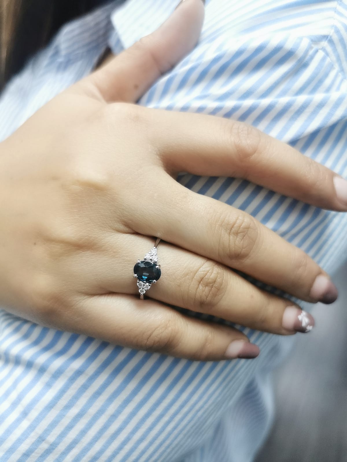 18K gold London Blue Topaz and diamond ring with a 1.30-carat oval-cut gemstone and 0.17 carats of round diamonds in a classic setting. Perfect blue gemstone ring for women.