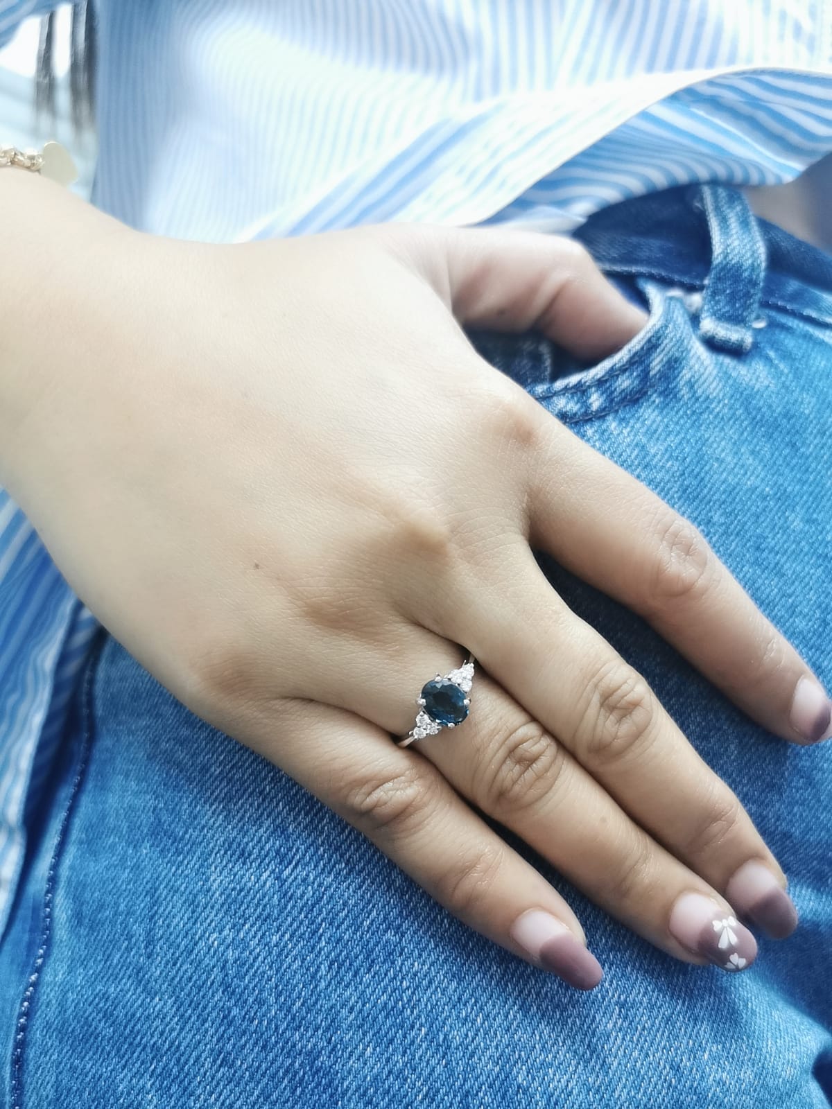 18K gold London Blue Topaz and diamond ring with a 1.30-carat oval-cut gemstone and 0.17 carats of round diamonds in a classic setting. Perfect blue gemstone ring for women.