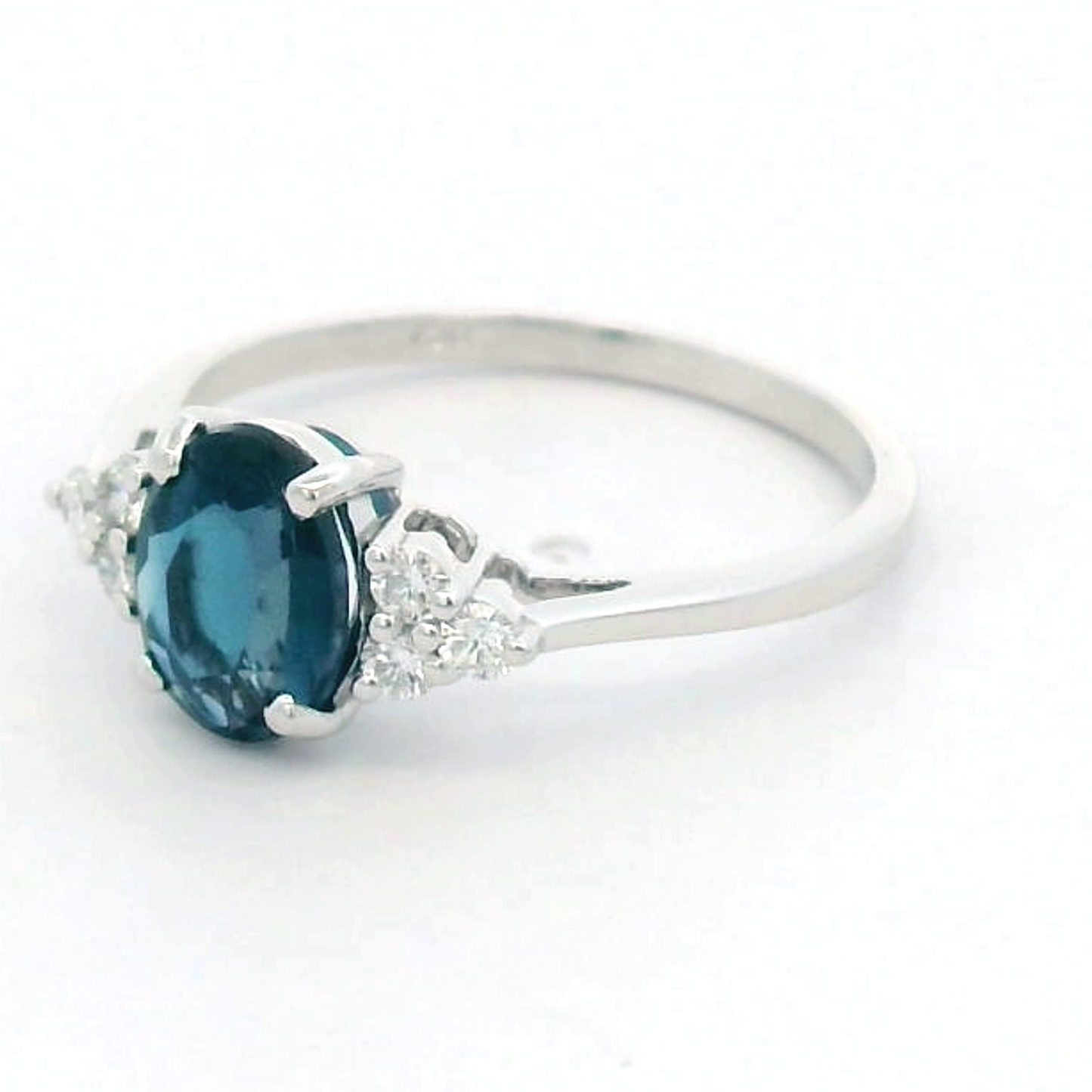 18K gold London Blue Topaz and diamond ring with a 1.30-carat oval-cut gemstone and 0.17 carats of round diamonds in a classic setting. Perfect blue gemstone ring for women.