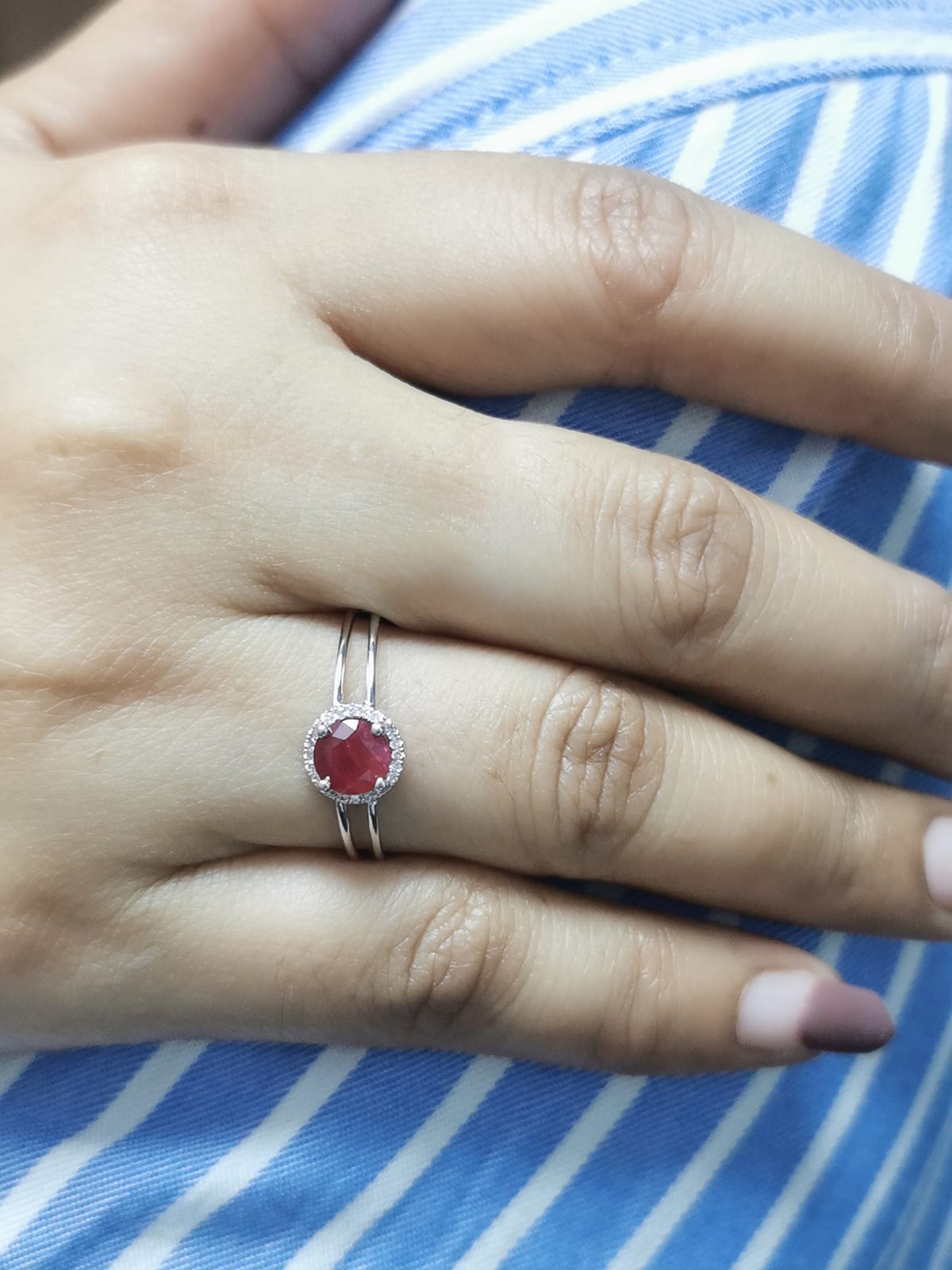 1.14 carat ruby and 0.05 carat diamond halo ring in 18K white gold with a modern double-band design.