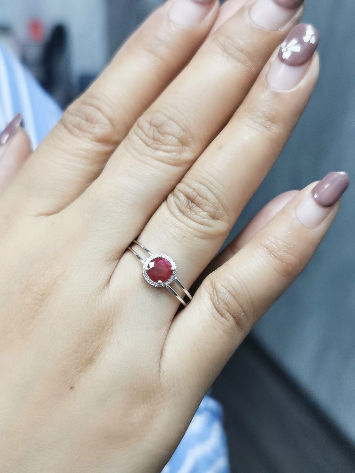1.14 carat ruby and 0.05 carat diamond halo ring in 18K white gold with a modern double-band design.