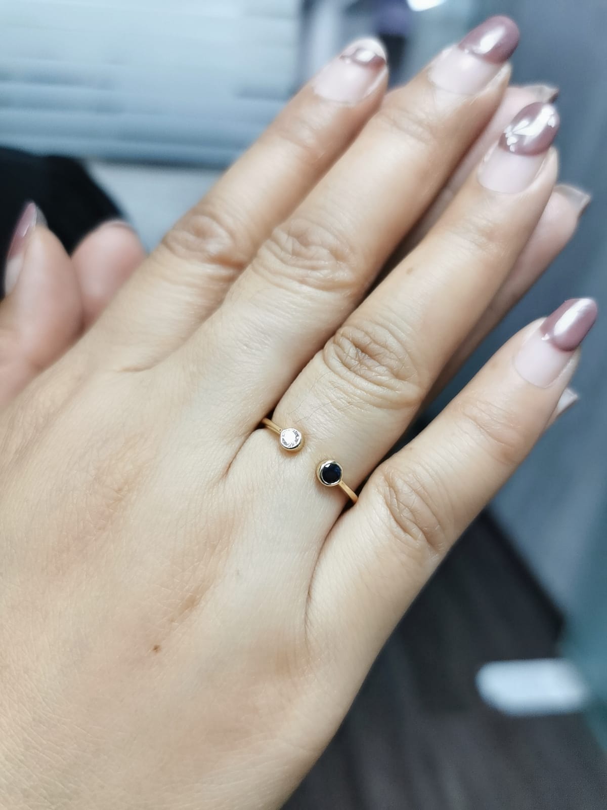 18K gold open ring with bezel-set round sapphire and diamond in minimalist design