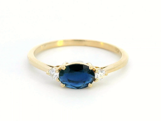 8K gold ring featuring a 0.57 carat oval blue sapphire and 0.09 carat diamonds