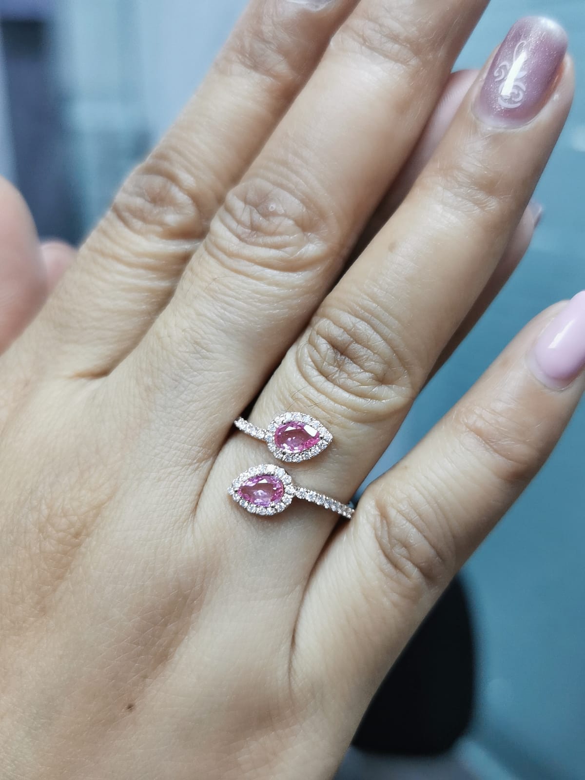 Toi et Moi ring in 18K rose gold with 1.44ct pear-shaped pink sapphires and 0.34ct diamond halo on a pavé band.