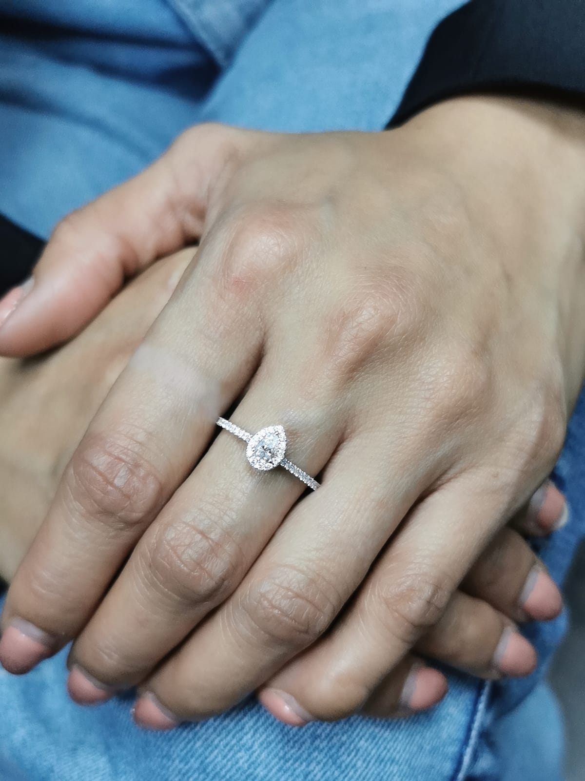 18K gold pear-cut diamond halo engagement ring with a 0.25ct center stone and accent diamonds on a delicate band.