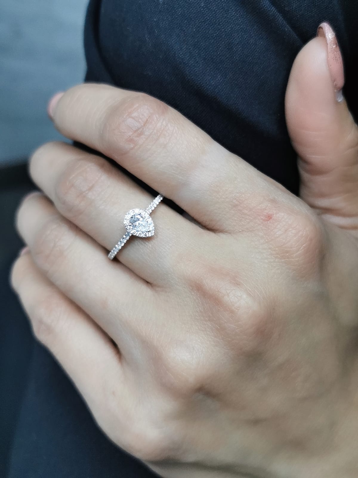 18K gold pear-cut diamond halo engagement ring with a 0.25ct center stone and accent diamonds on a delicate band.