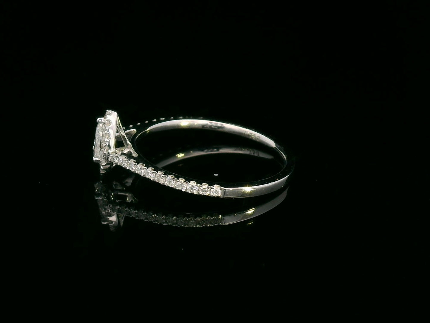 18K gold pear-cut diamond halo engagement ring with a 0.25ct center stone and accent diamonds on a delicate band.