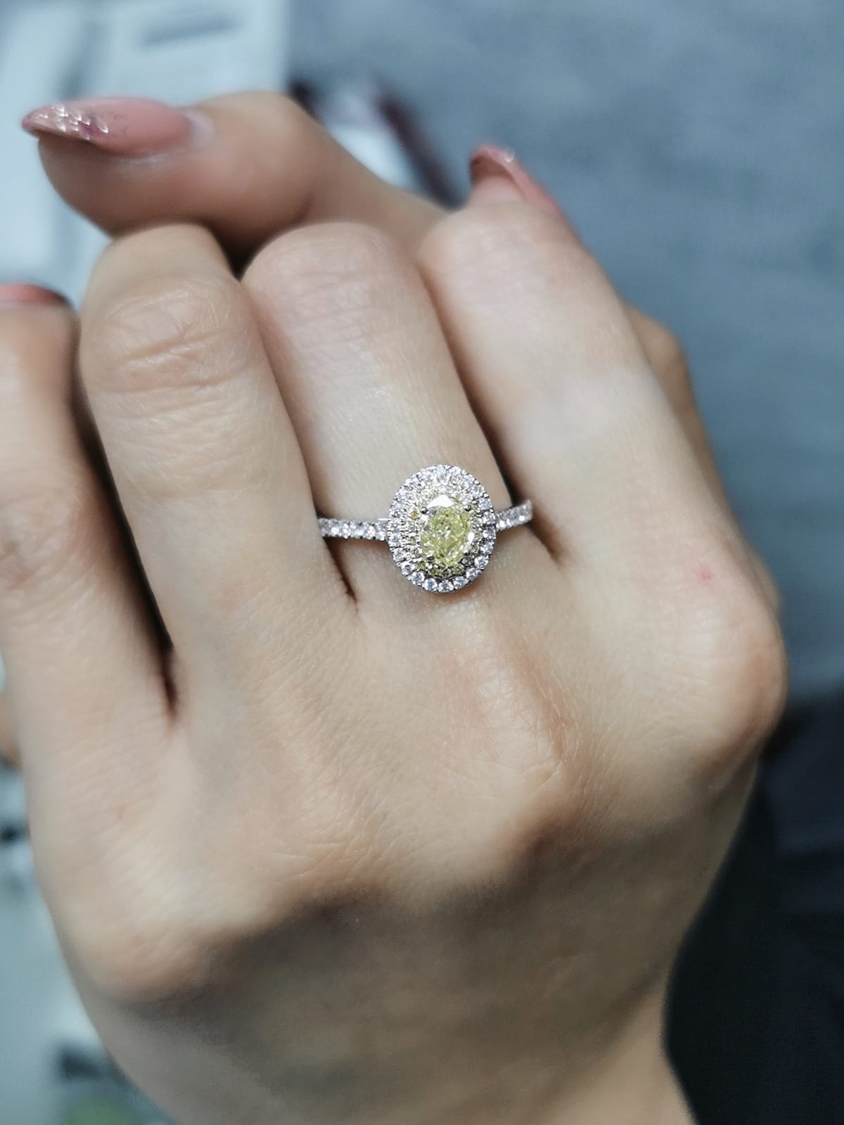 1.07ct fancy yellow diamond halo engagement ring with a radiant-cut center stone, double diamond halo, and pavé band in 18K gold.