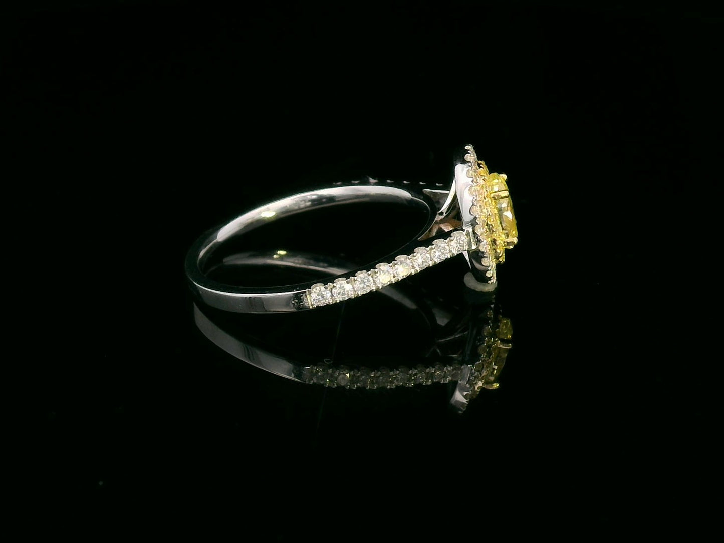 1.07ct fancy yellow diamond halo engagement ring with a radiant-cut center stone, double diamond halo, and pavé band in 18K gold.
