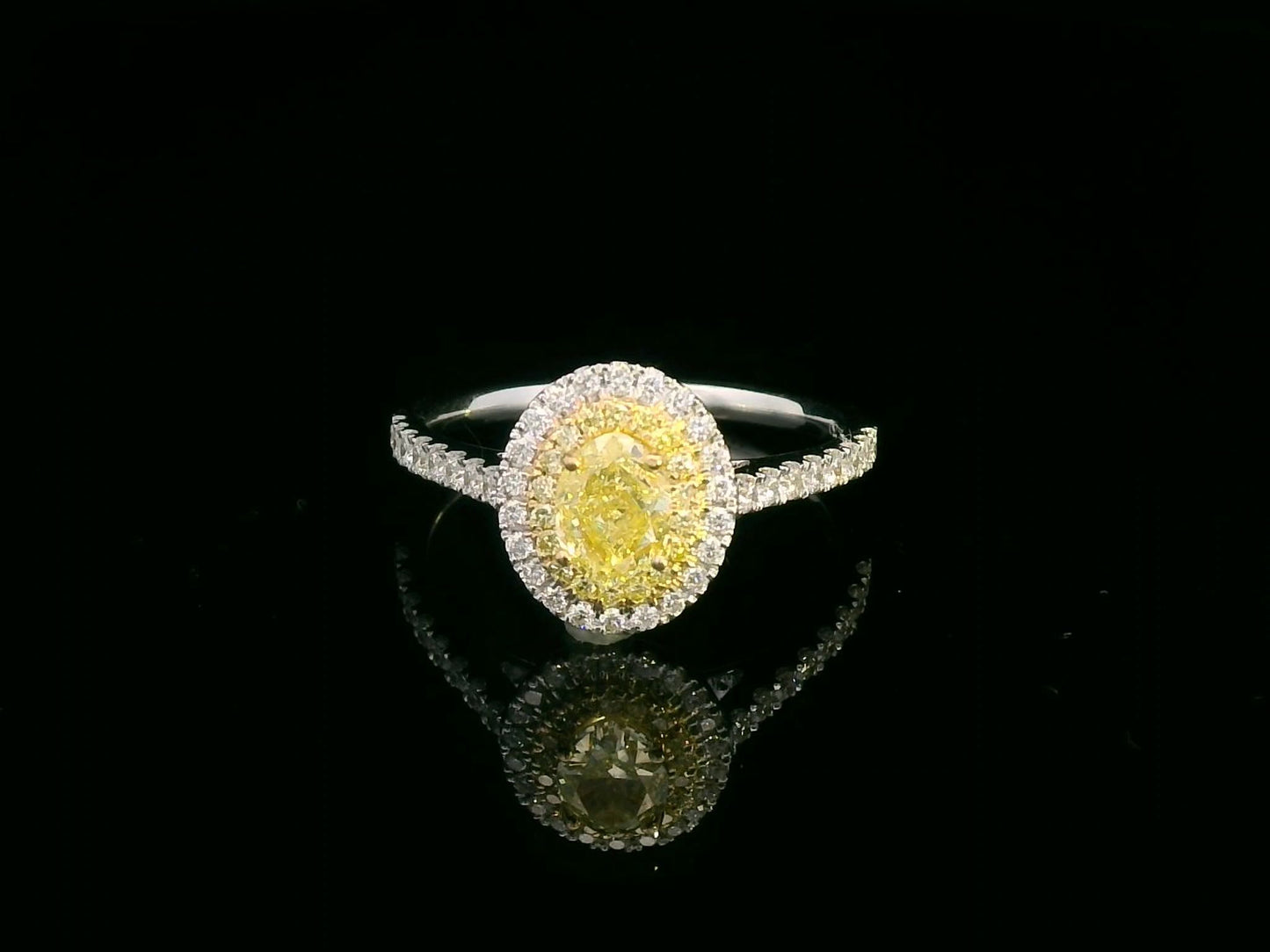 1.07ct fancy yellow diamond halo engagement ring with a radiant-cut center stone, double diamond halo, and pavé band in 18K gold.