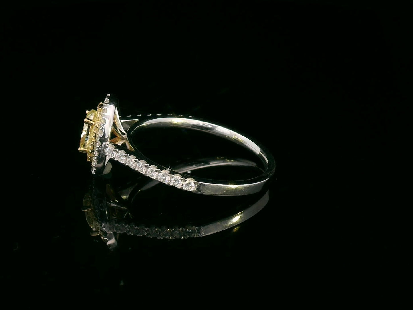1.07ct fancy yellow diamond halo engagement ring with a radiant-cut center stone, double diamond halo, and pavé band in 18K gold.