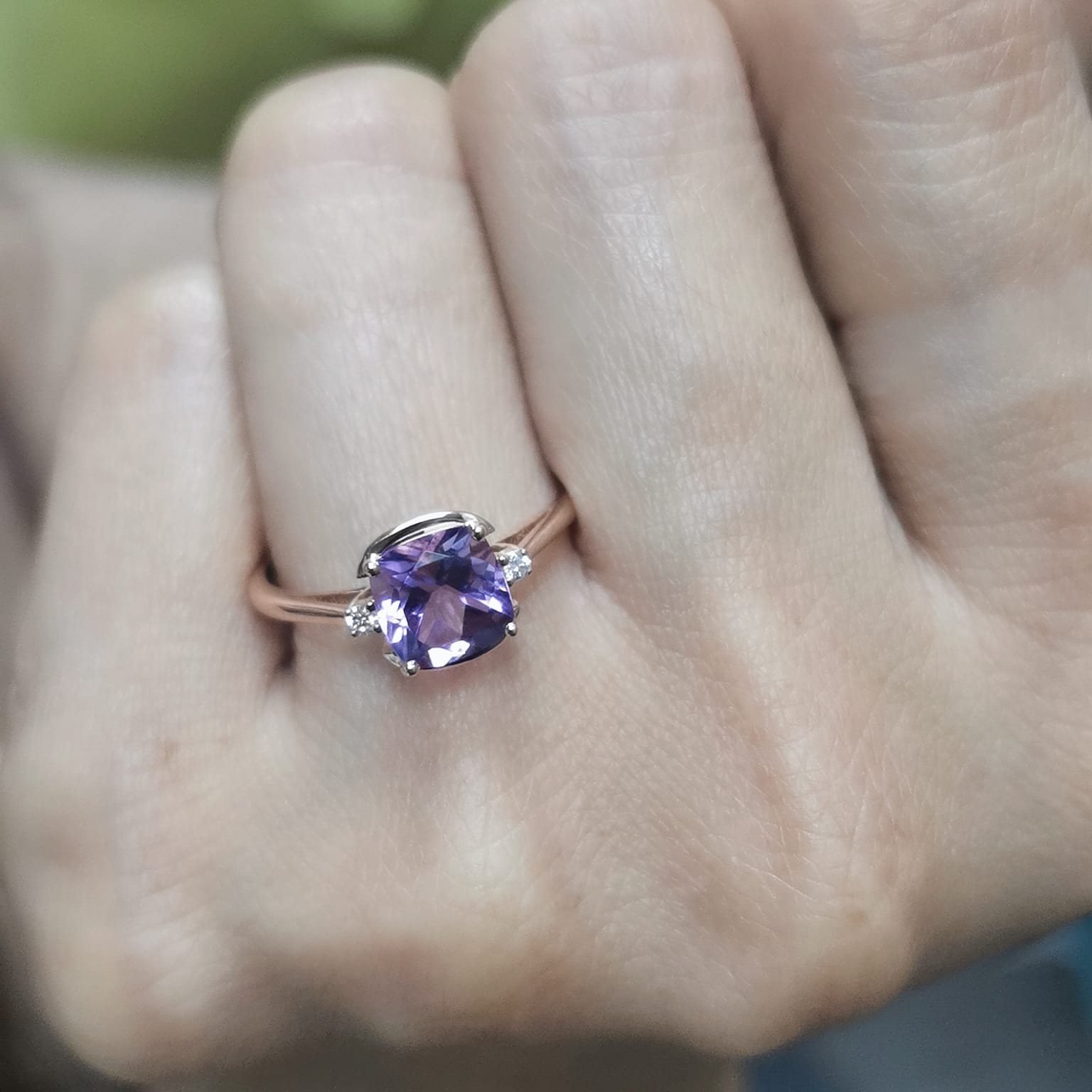 18K gold ring with a 1.51-carat cushion-cut purple amethyst center stone, accented by two round diamonds totaling 0.04 carat.