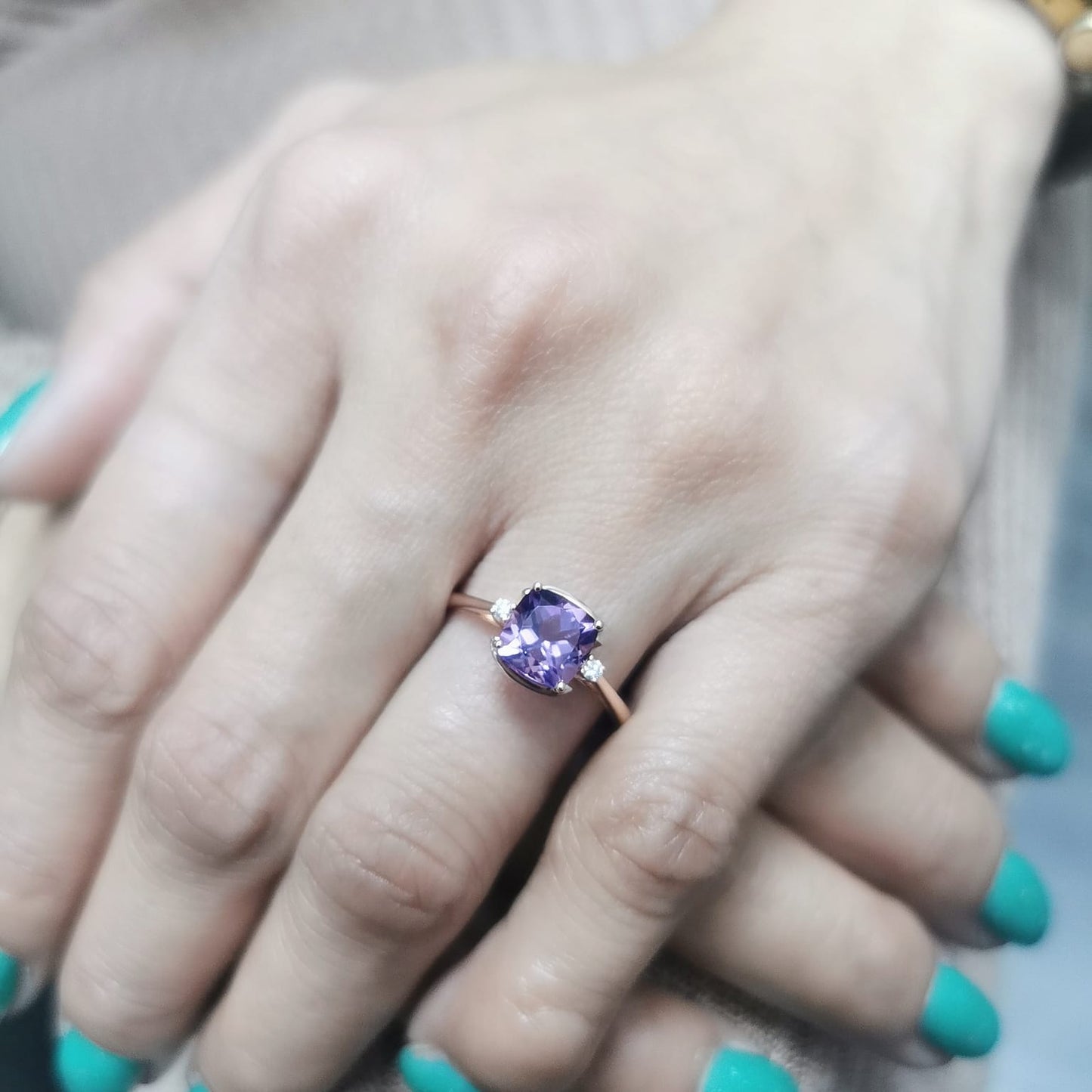18K gold ring with a 1.51-carat cushion-cut purple amethyst center stone, accented by two round diamonds totaling 0.04 carat.