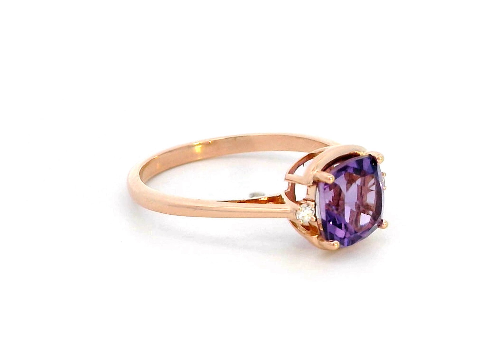 18K gold ring with a 1.51-carat cushion-cut purple amethyst center stone, accented by two round diamonds totaling 0.04 carat.