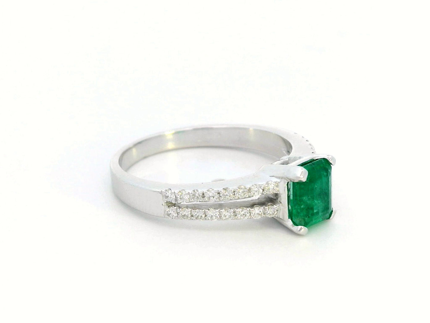18K white gold emerald ring featuring a 0.78-carat emerald-cut green emerald with 0.25-carat diamond accents on a split band.