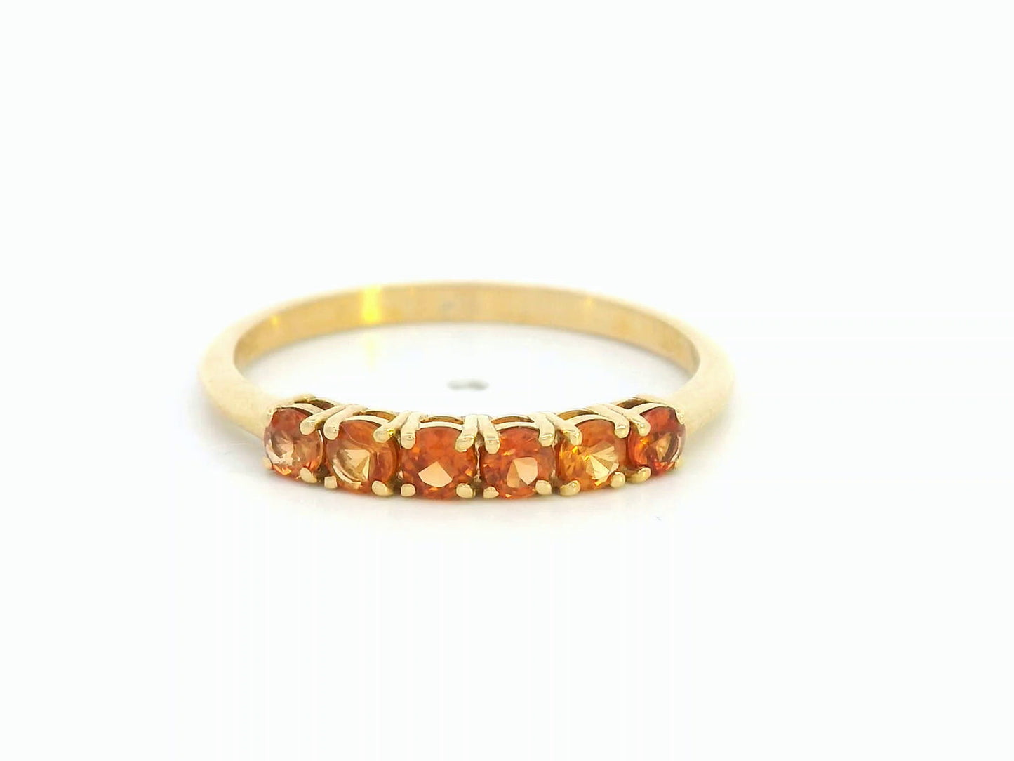 18K yellow gold ring with six round-cut orange sapphires in a half eternity setting
