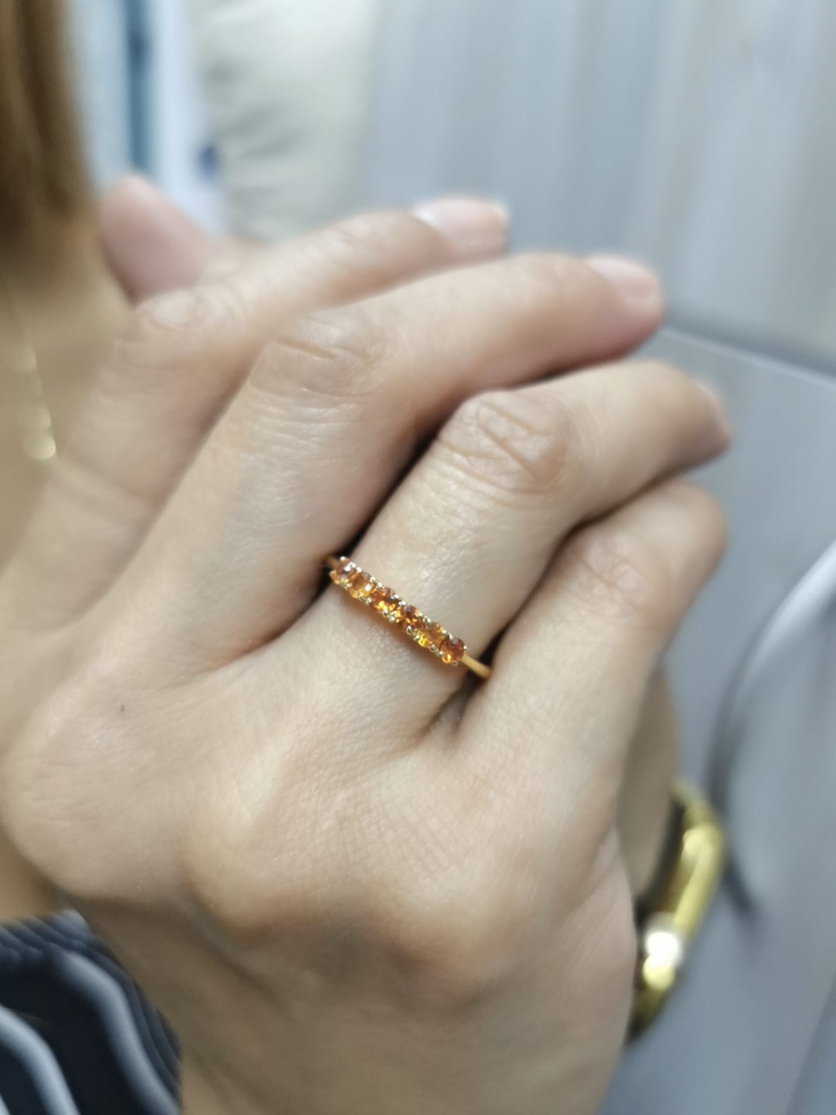 18K yellow gold ring with six round-cut orange sapphires in a half eternity setting