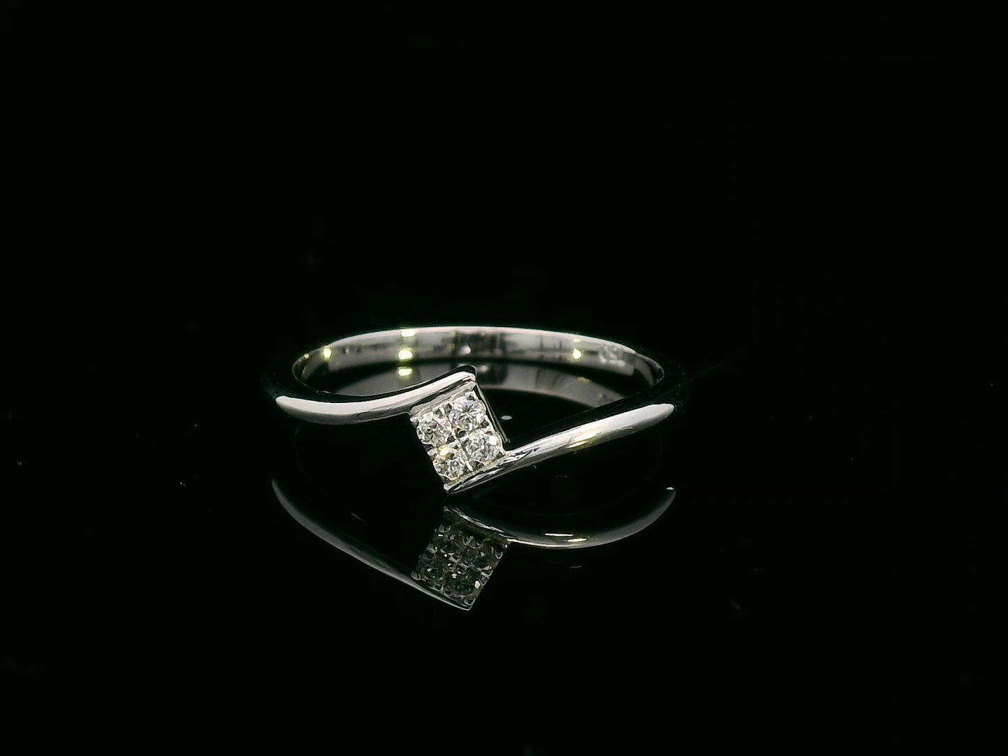 Minimalist 18K gold bypass ring with 0.06 carat total diamond weight, featuring a sleek modern design and geometric diamond setting.