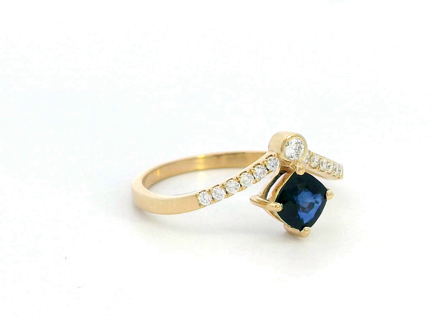 18K gold blue sapphire and diamond ring featuring a 0.51 carat cushion-cut sapphire and 0.14 carats of round-cut diamonds, set in an elegant design. Perfect for special occasions and fine jewelry lovers