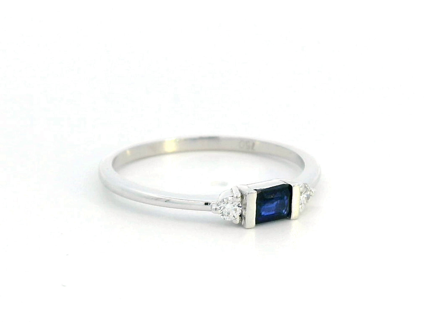 18K gold ring with a baguette-cut blue sapphire (0.26 carats) and round-cut diamonds (0.08 carats), bezel-set on a slim band—perfect for stacking or wearing alone.