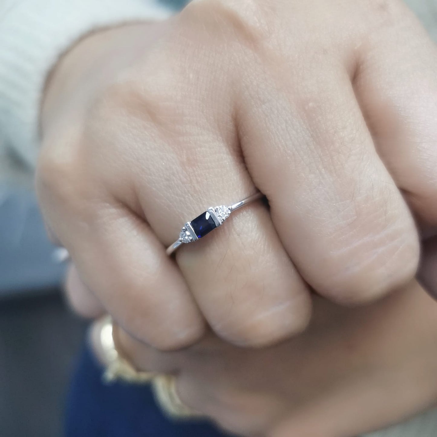 18K gold ring with a baguette-cut blue sapphire (0.26 carats) and round-cut diamonds (0.08 carats), bezel-set on a slim band—perfect for stacking or wearing alone.