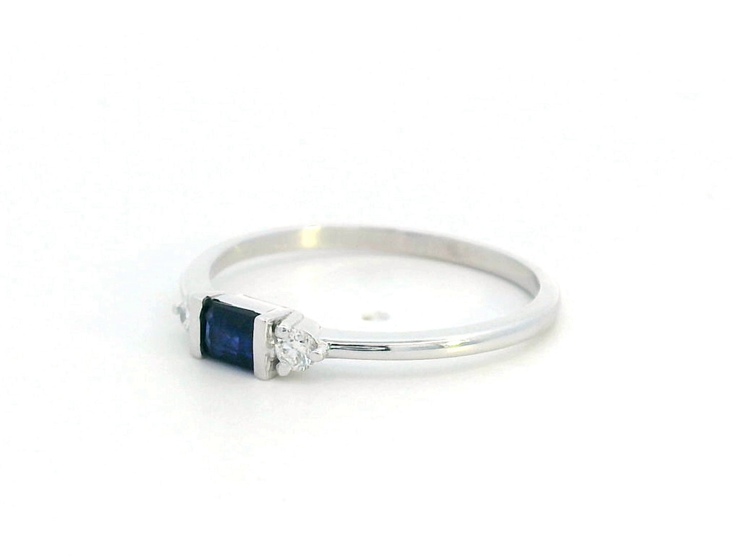 18K gold ring with a baguette-cut blue sapphire (0.26 carats) and round-cut diamonds (0.08 carats), bezel-set on a slim band—perfect for stacking or wearing alone.