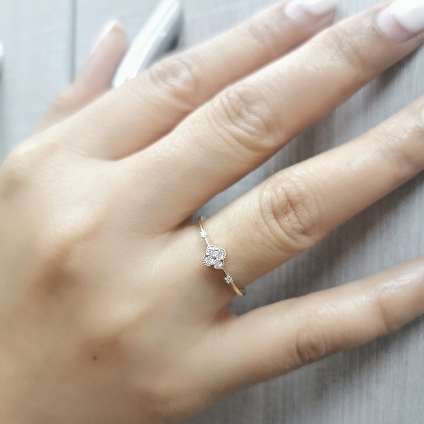 Minimalist 18K gold diamond clover ring with 0.12 carat total weight, featuring a delicate band and modern, elegant design.