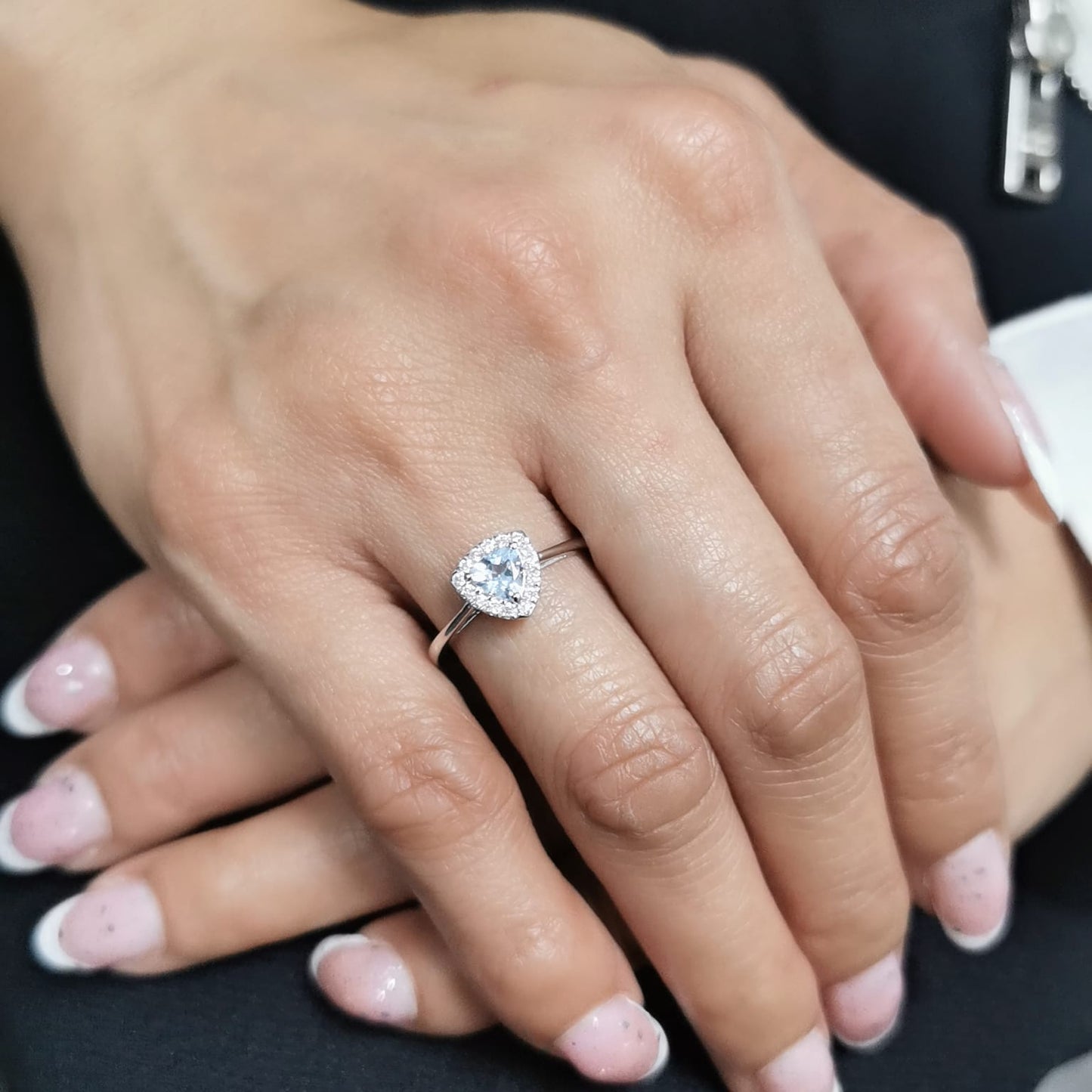 Trillion-cut aquamarine and diamond halo ring in 18K white gold, featuring a 0.50-carat aquamarine center stone surrounded by 0.15-carat diamonds.