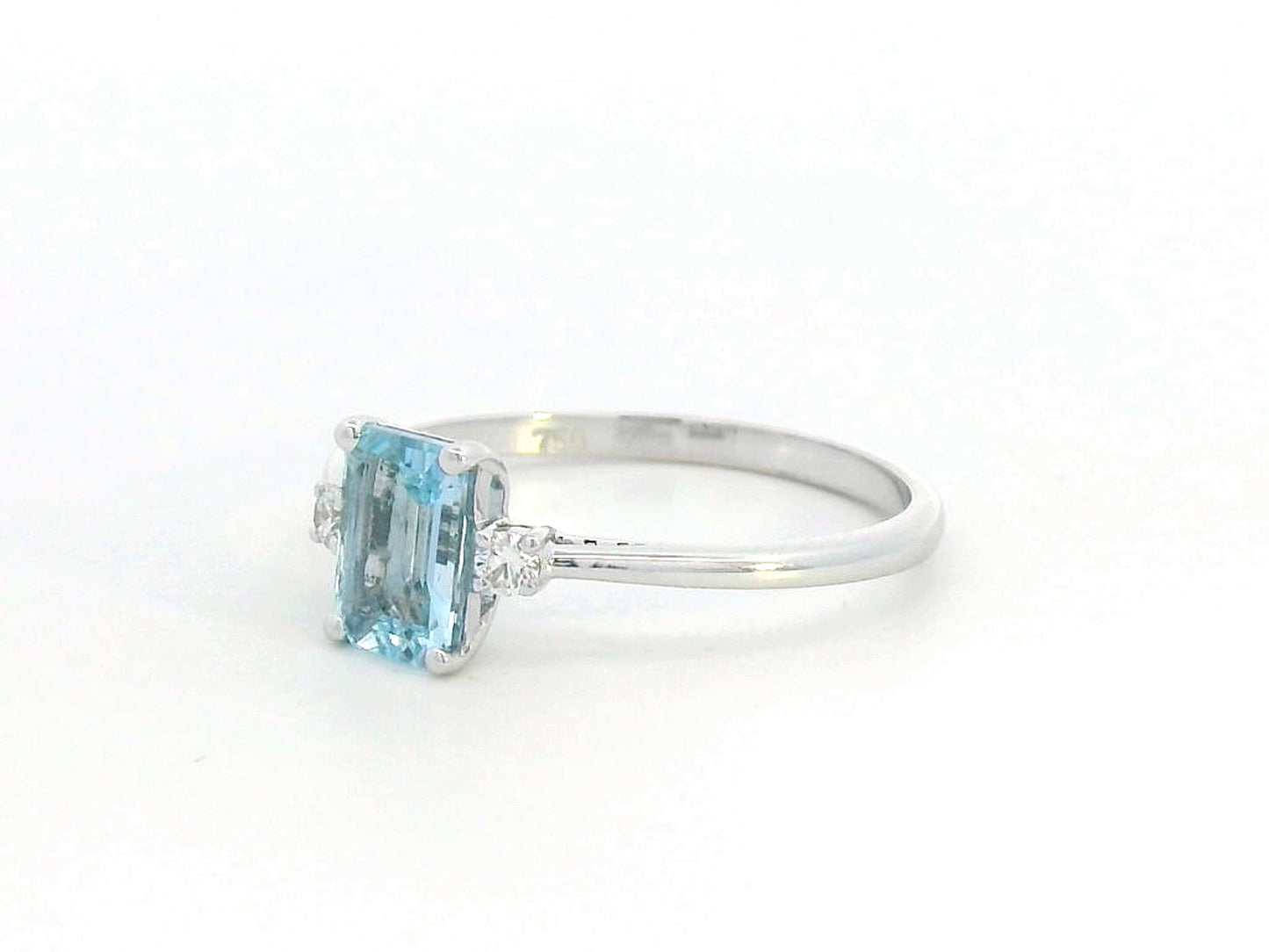 18K white gold aquamarine and diamond ring featuring a 0.65-carat emerald-cut aquamarine with 0.07-carat round diamonds in a minimalist fine jewelry design – perfect for engagements, gifts, and March birthstone jewelry.