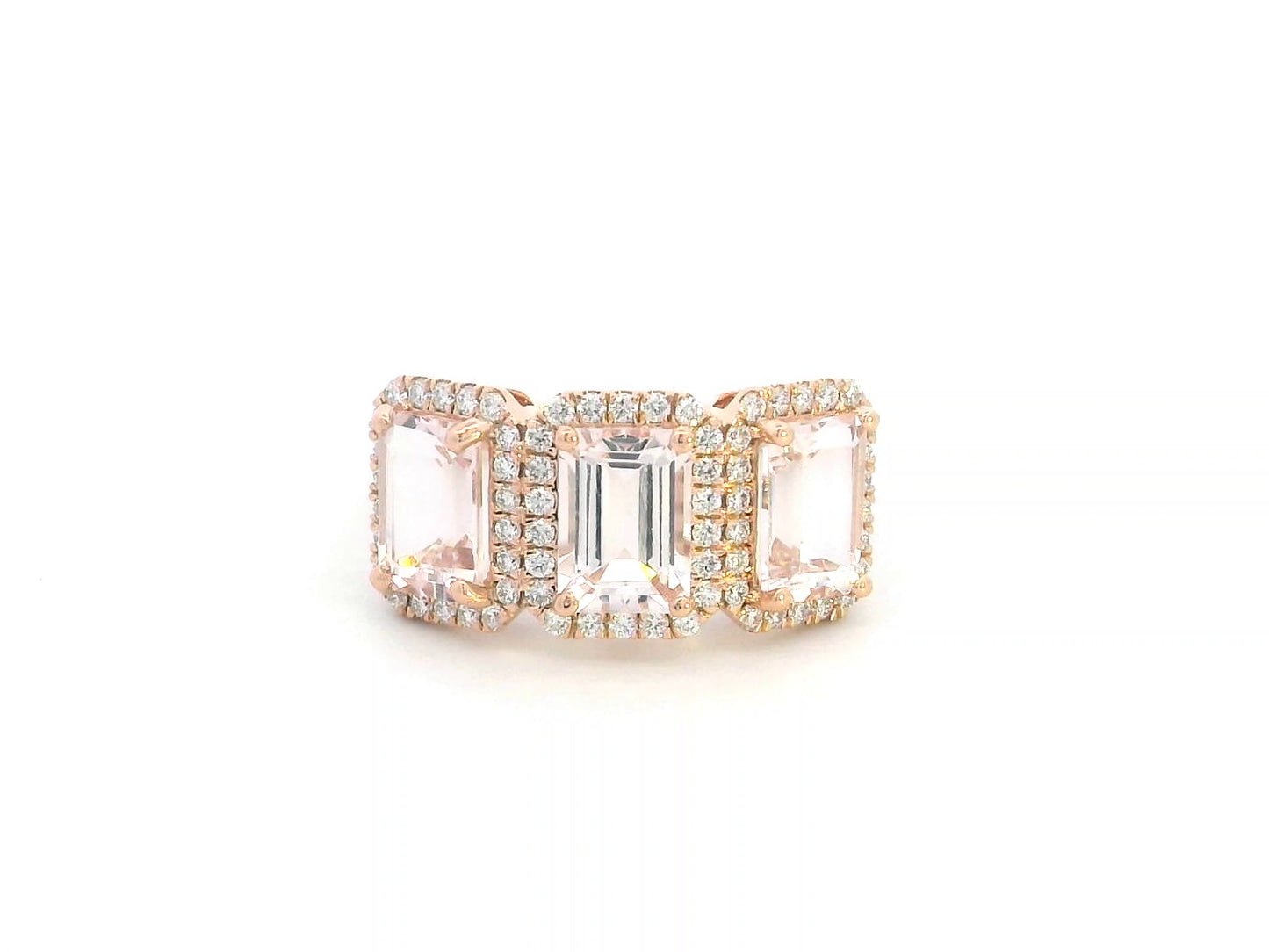 8K rose gold three-stone morganite and diamond ring featuring 2.79 carats of emerald-cut morganite with 0.38 carats of brilliant diamonds in a halo setting. A perfect statement or anniversary ring
