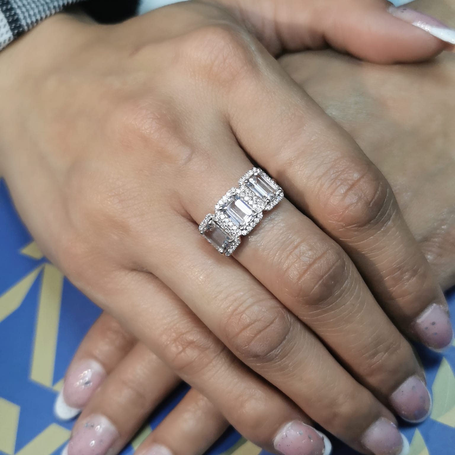 18K rose gold three-stone morganite and diamond ring featuring 2.79 carats of emerald-cut morganite with 0.38 carats of brilliant diamonds in a halo setting. A perfect statement or anniversary ring