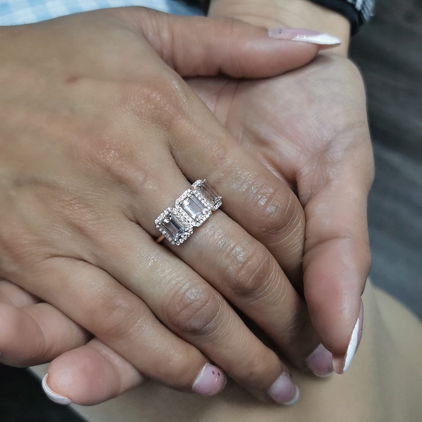 18K rose gold three-stone morganite and diamond ring featuring 2.79 carats of emerald-cut morganite with 0.38 carats of brilliant diamonds in a halo setting. A perfect statement or anniversary ring