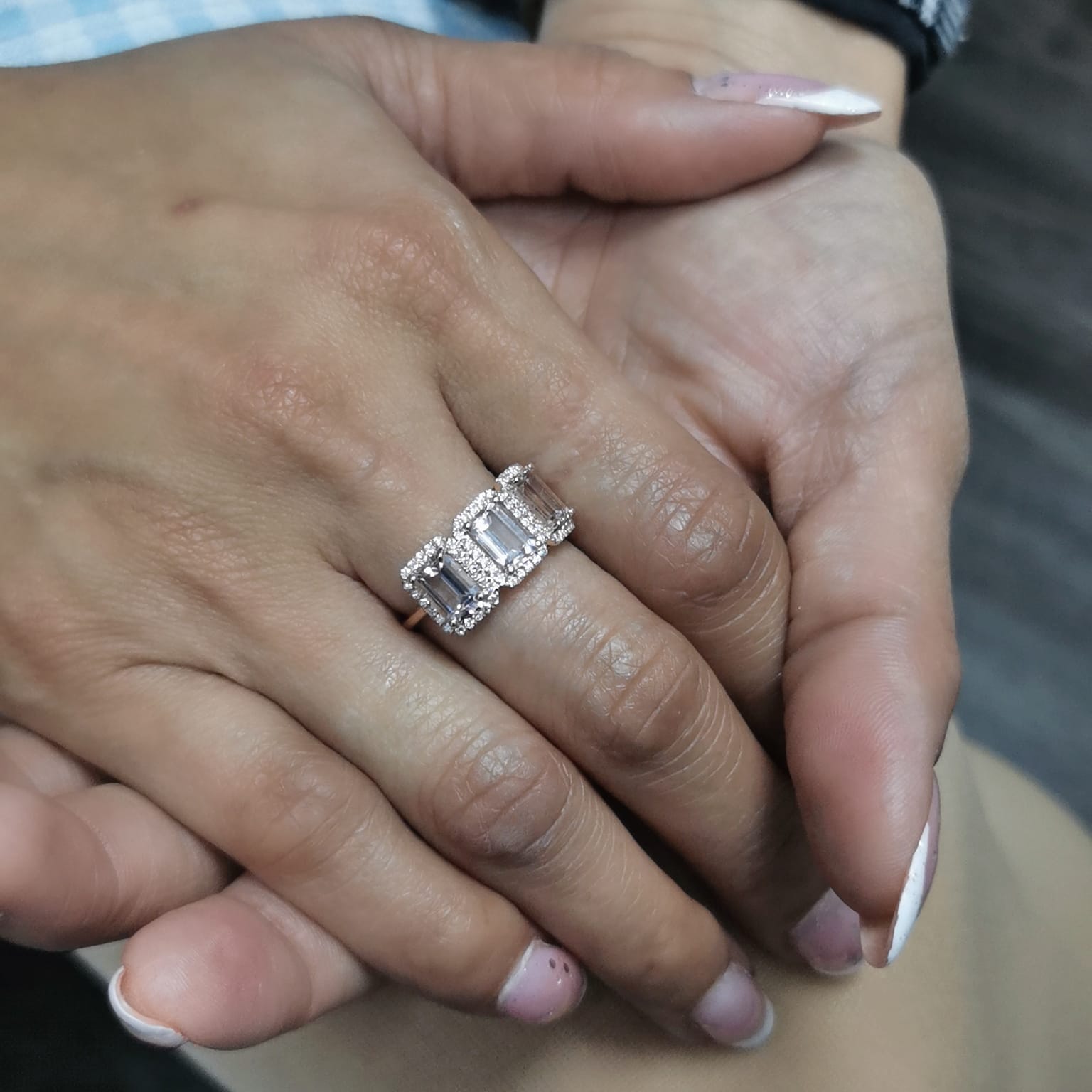 18K rose gold three-stone morganite and diamond ring featuring 2.79 carats of emerald-cut morganite with 0.38 carats of brilliant diamonds in a halo setting. A perfect statement or anniversary ring