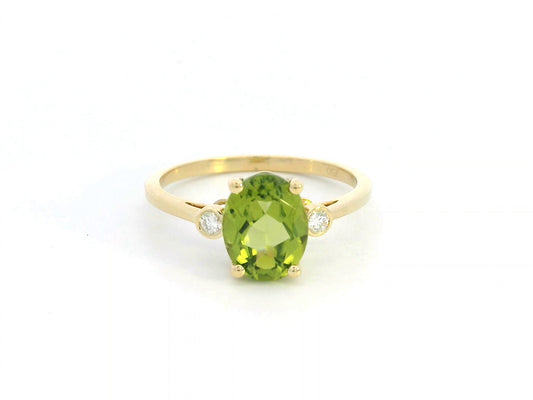 Oval peridot and diamond ring in 18K gold, featuring a 2.02-carat green peridot with 0.06-carat diamond accents.