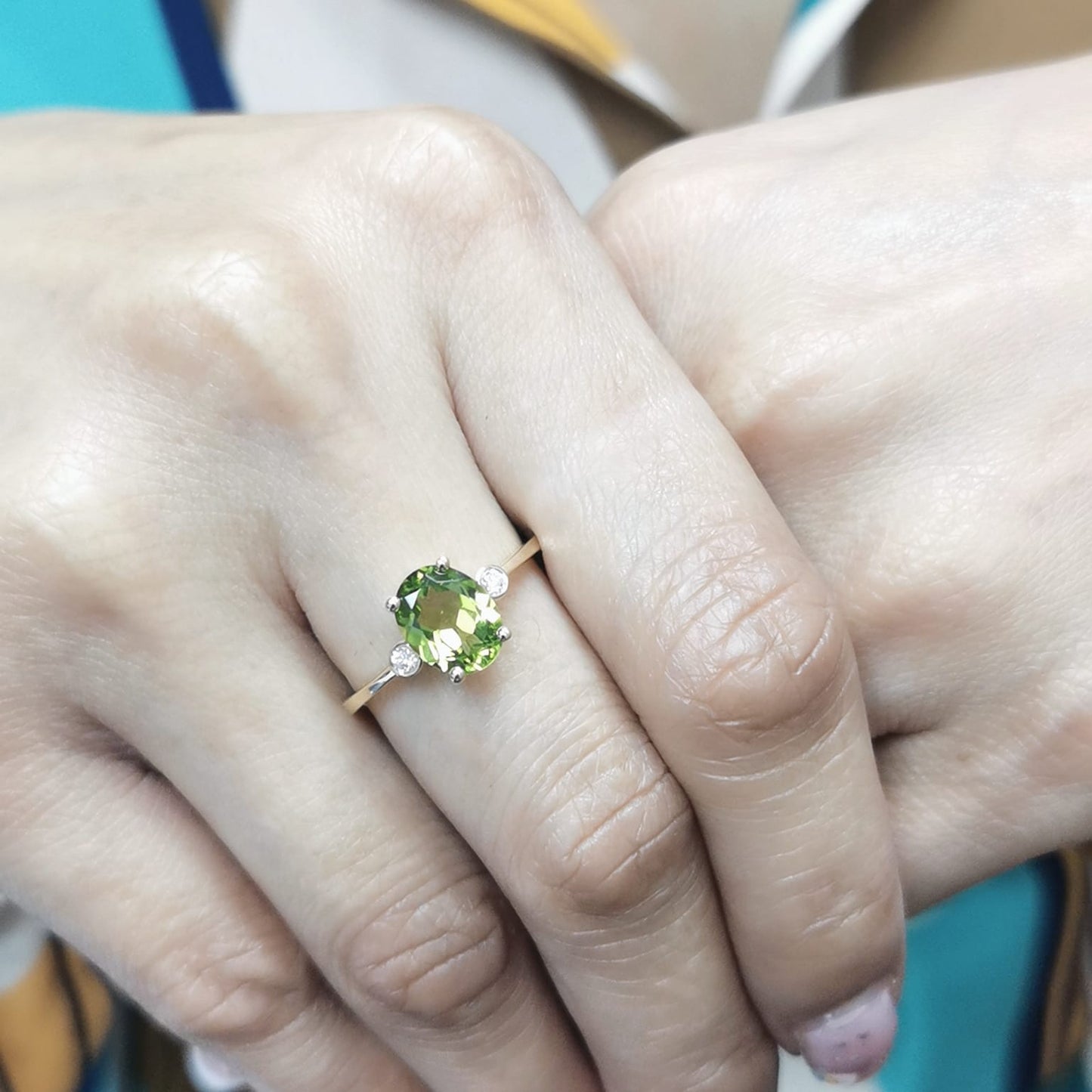 Oval peridot and diamond ring in 18K gold, featuring a 2.02-carat green peridot with 0.06-carat diamond accents.