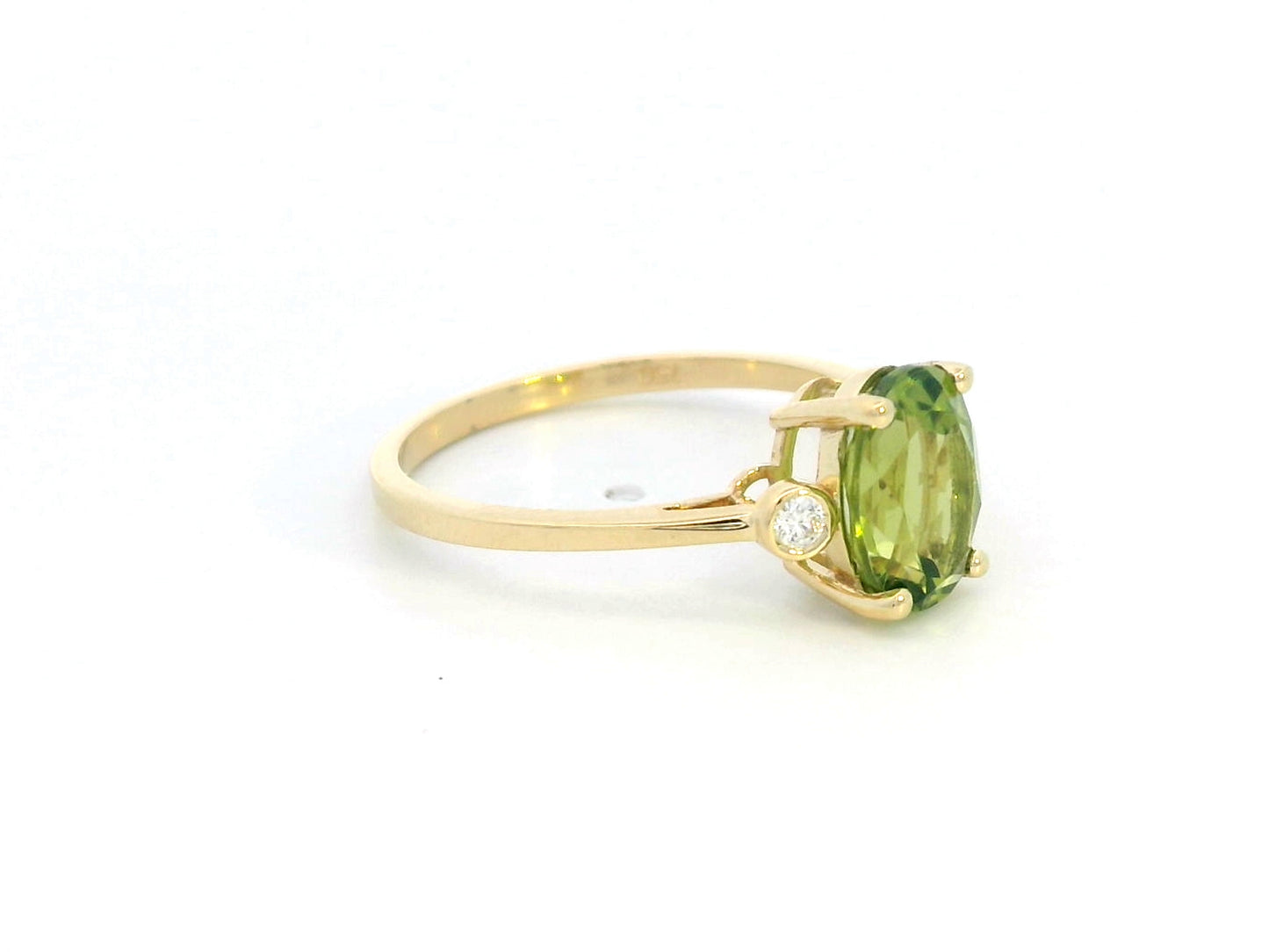 Oval peridot and diamond ring in 18K gold, featuring a 2.02-carat green peridot with 0.06-carat diamond accents.