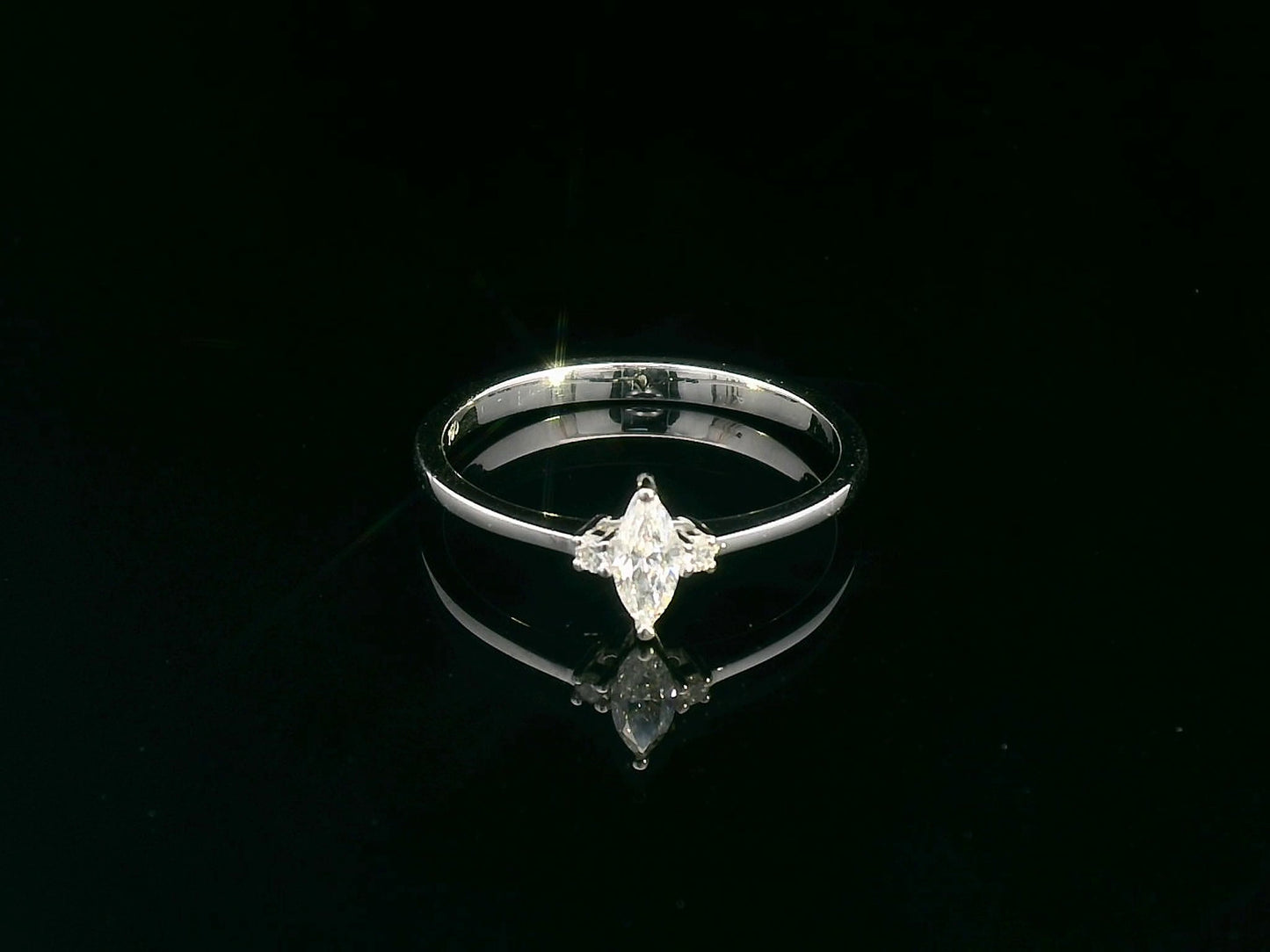 18K gold marquise diamond ring featuring a 0.19-carat marquise-cut center stone with 0.04-carat round diamond accents. Perfect as an engagement ring, stacking ring, or elegant everyday jewelry