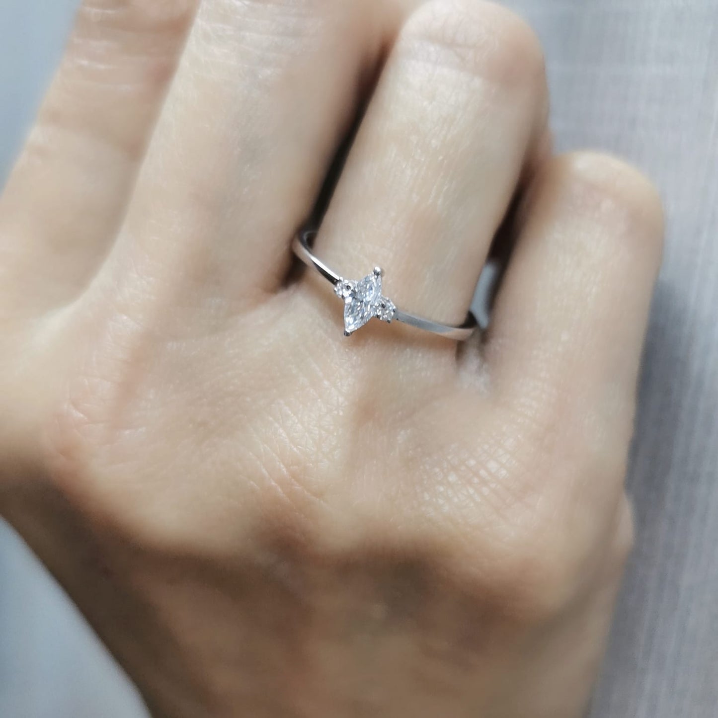 18K gold marquise diamond ring featuring a 0.19-carat marquise-cut center stone with 0.04-carat round diamond accents. Perfect as an engagement ring, stacking ring, or elegant everyday jewelry