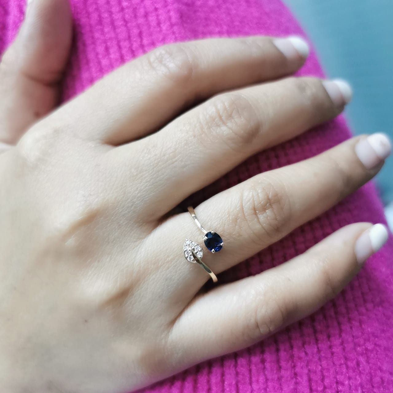 18K yellow gold sapphire and diamond ring featuring a 0.45-carat blue sapphire and 0.06-carat diamonds in an elegant bypass design