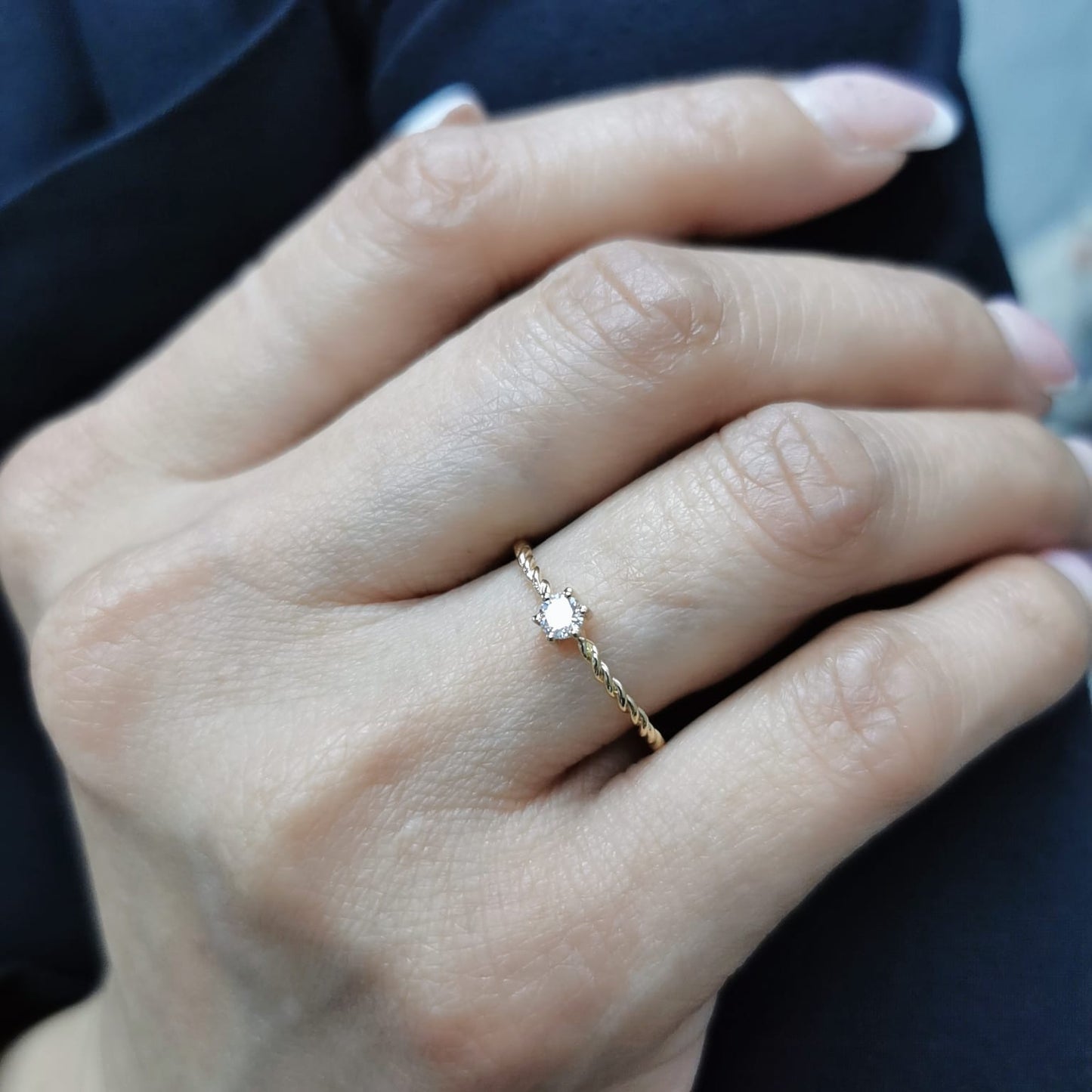 18K yellow gold twisted band diamond ring featuring a 0.15-carat round solitaire diamond in a delicate rope-style design