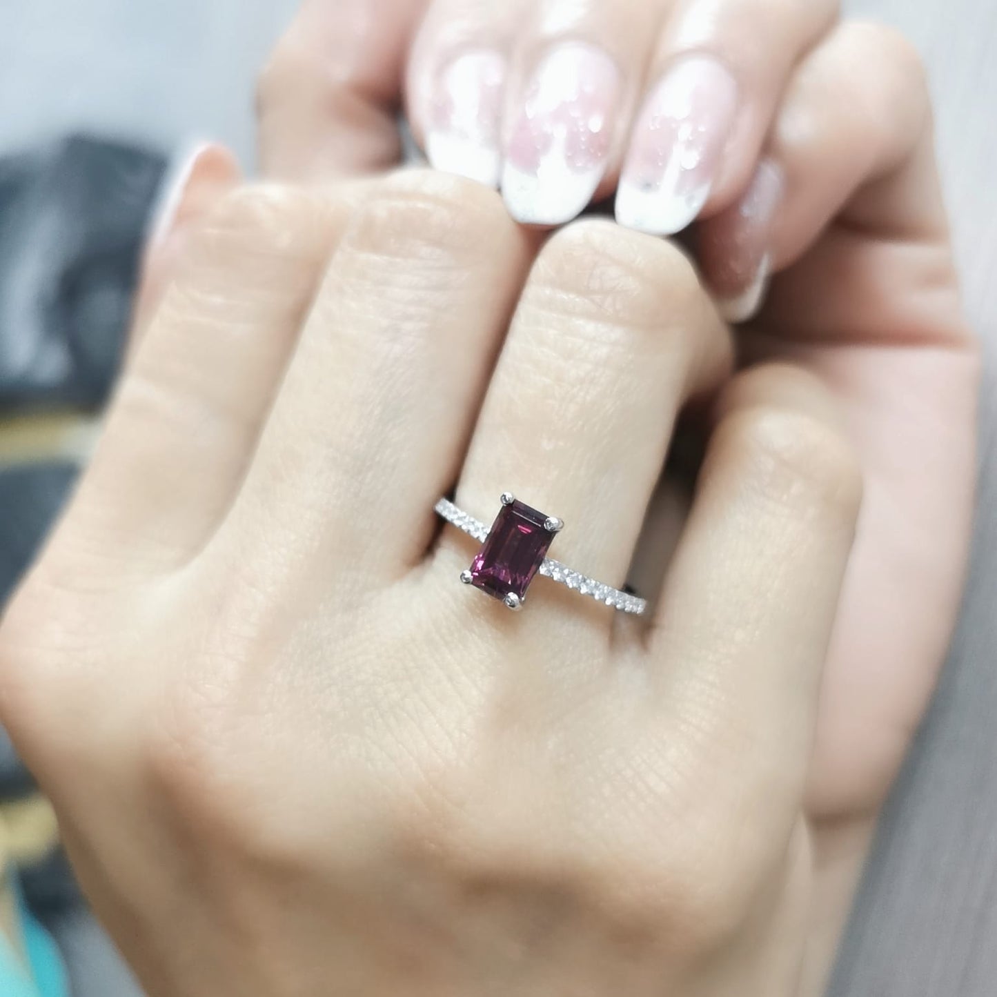 18K white gold ring featuring a 1.46-carat emerald-cut Rhodolite with 0.18 carats of diamonds on the band.