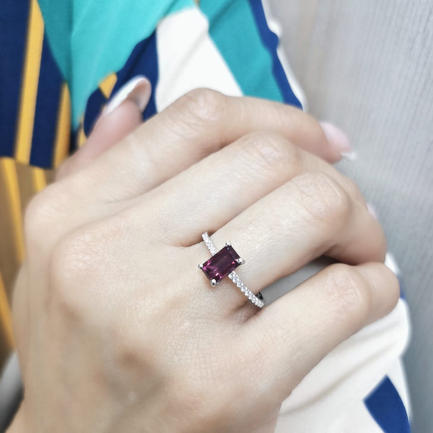 18K white gold ring featuring a 1.46-carat emerald-cut Rhodolite with 0.18 carats of diamonds on the band.