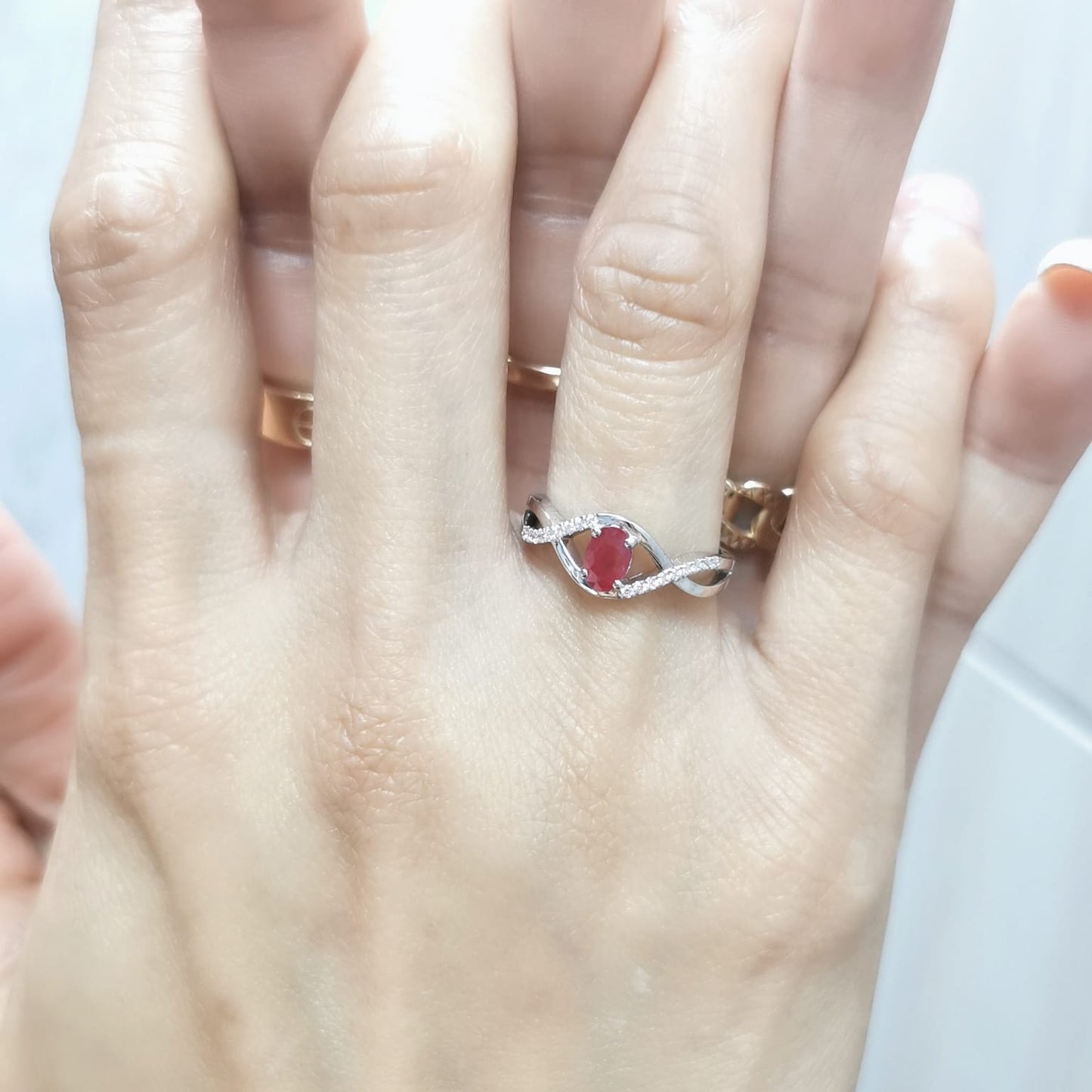 18K White Gold Infinity Ring with 0.48 Carat Oval Ruby and 0.09 Carat Diamonds