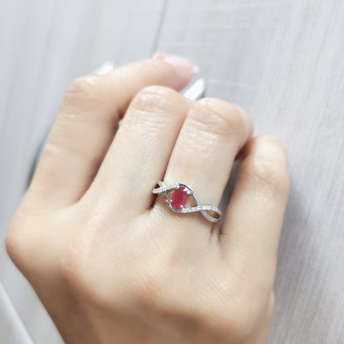 18K White Gold Infinity Ring with 0.48 Carat Oval Ruby and 0.09 Carat Diamonds