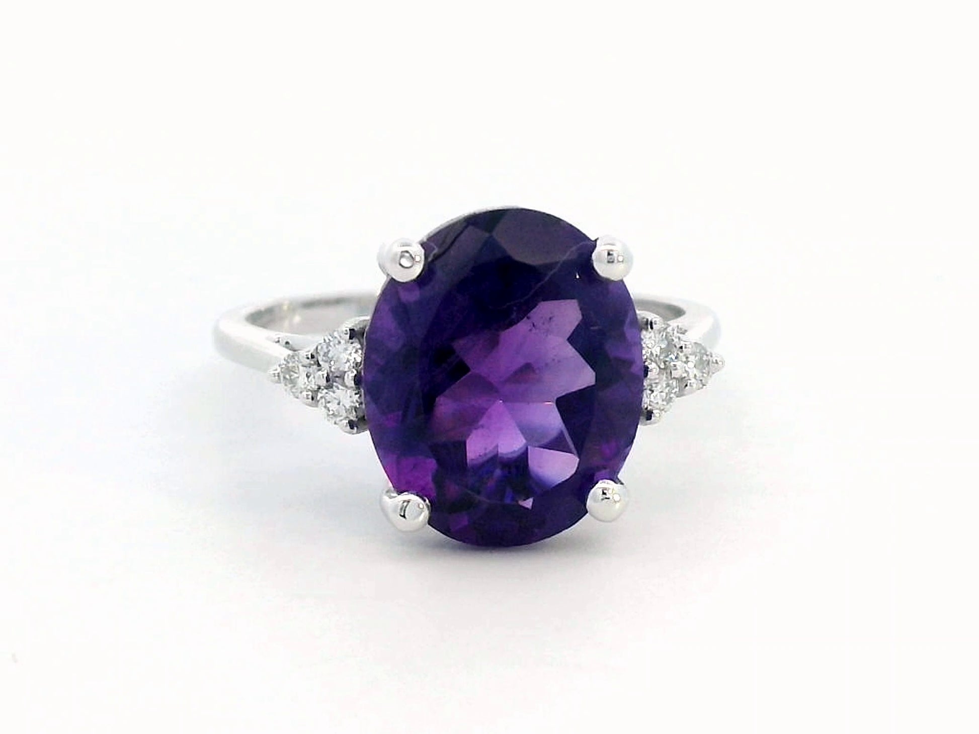 18K gold ring featuring a 4.37-carat oval-cut amethyst, accented by 0.13 carats of round diamonds.