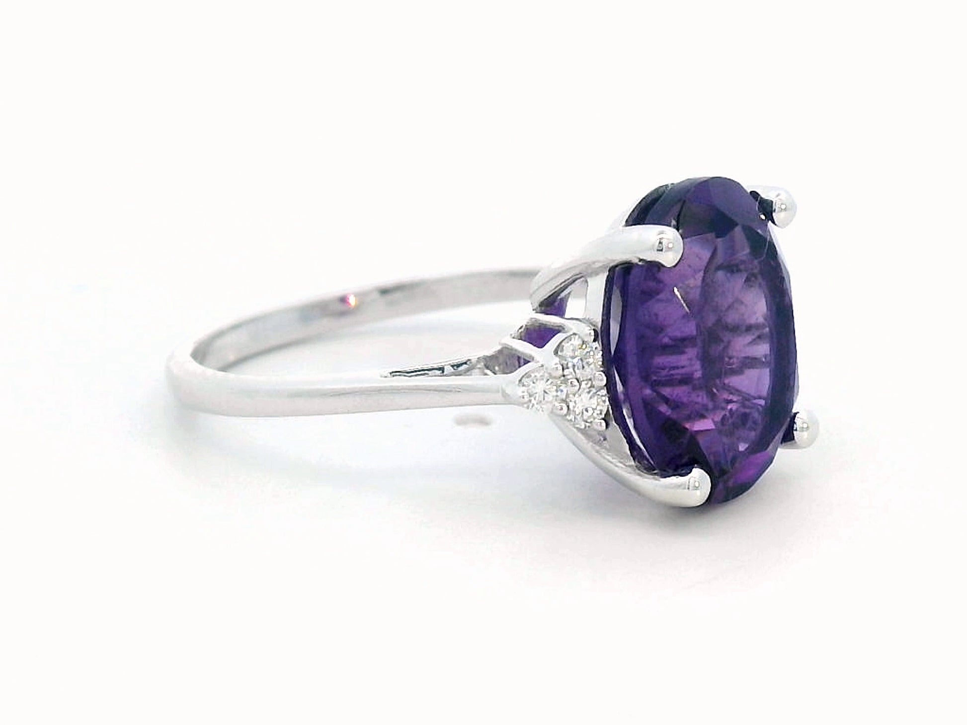 18K gold ring featuring a 4.37-carat oval-cut amethyst, accented by 0.13 carats of round diamonds.