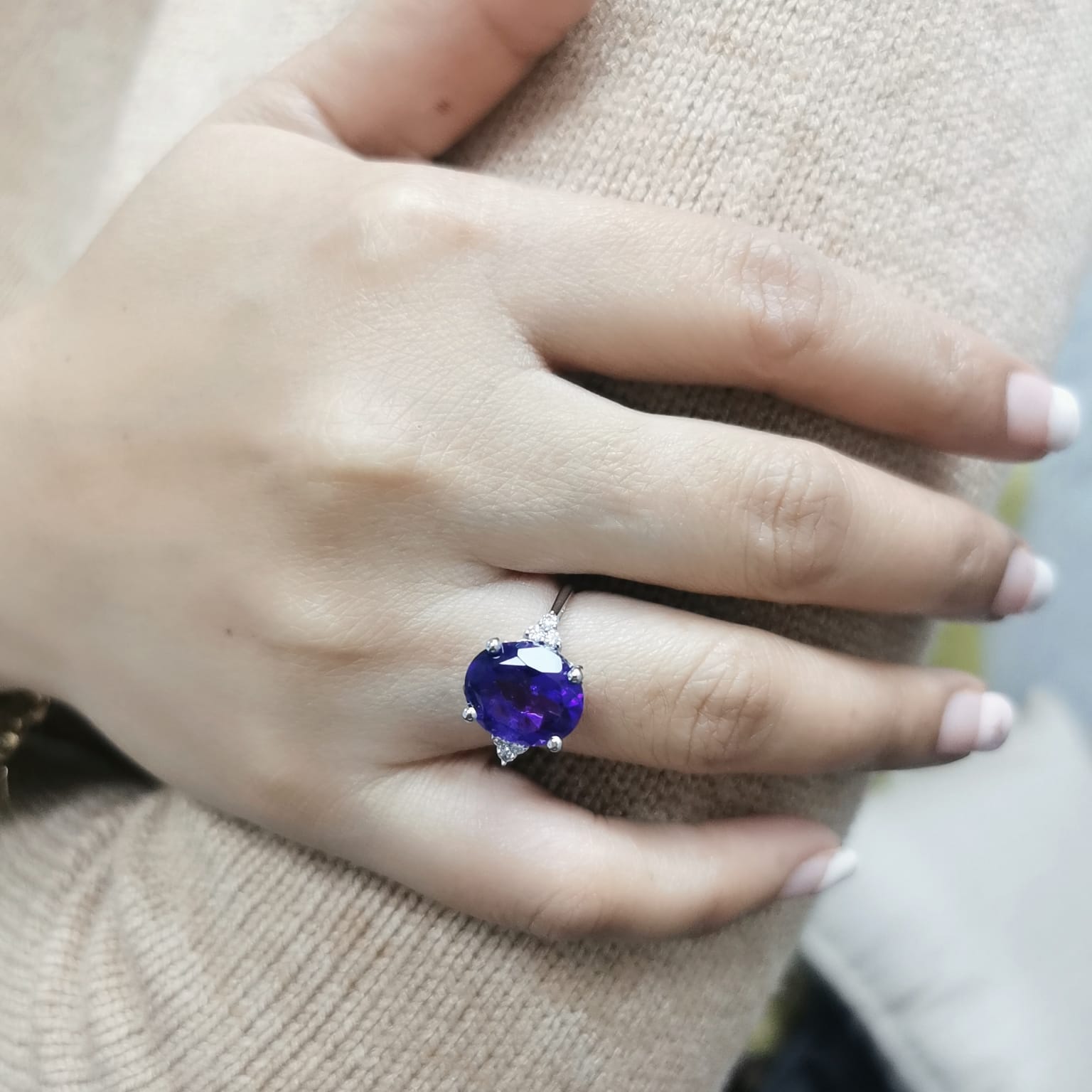 18K gold ring featuring a 4.37-carat oval-cut amethyst, accented by 0.13 carats of round diamonds.